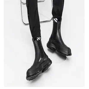 Dettaglio di stivali platform in pelle nera da uomo con suola spessa e finitura liscia.