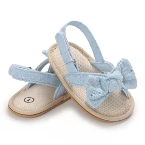 Close-up view of light blue baby girl sandals featuring a cute bow and floral embroidery