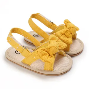 Detailed view of yellow baby girl summer sandals with lace bow and soft sole