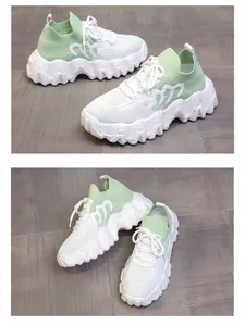 Dettaglio della tomaia in maglia traspirante e suola platform ondulata su sneaker bianco-verdi