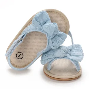 Close-up of light blue baby girl sandals with breathable fabric and bow detail