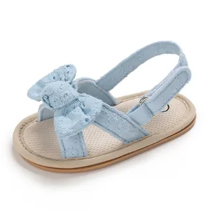 Close-up detail of light blue floral embroidered baby girl sandals with bow and soft sole