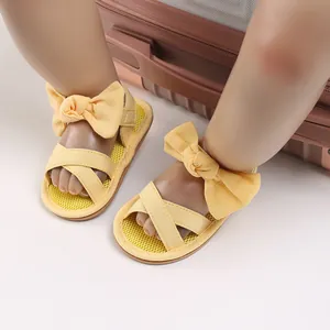 Detailed view of yellow baby walking sandals with a cute fabric bow and soft sole