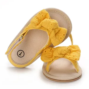 Detailed view of yellow baby girl sandals featuring a decorative breathable lace bow