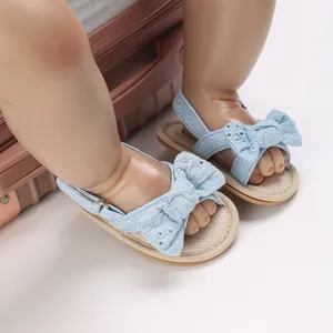 Close-up of light blue baby girl summer sandals featuring a large embroidered lace bow