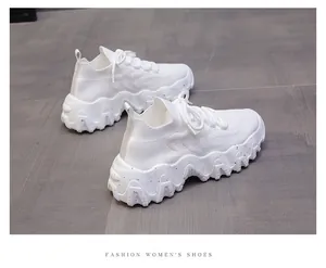 Vista dettagliata di sneakers a calzino bianche con suole platform ondulate spesse.
