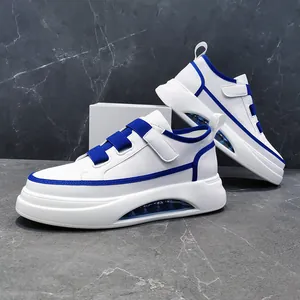 Detail of men's white sneakers with blue trim, thick sole, and air cushion feature