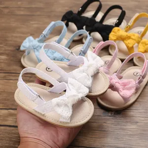 Detail view of baby girl summer sandals with soft soles and bow accents