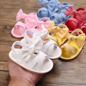 Close-up detail showing colorful baby girl sandals with bow tie and soft breathable mesh sole.