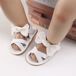 Close-up of white baby girl walking sandals with bow knot and soft sole for summer