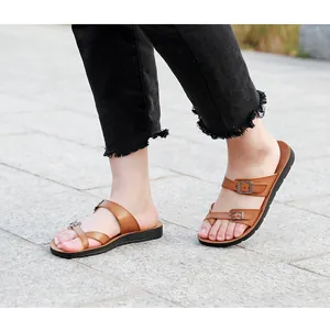 Close-up of brown double-strap flat sandals with adjustable buckles