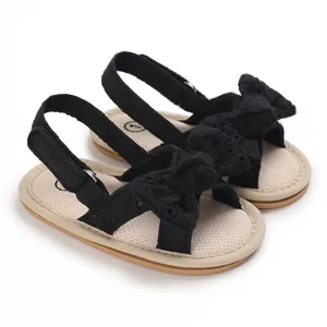 Close-up of black lace baby girl sandals with decorative bow and breathable soft sole