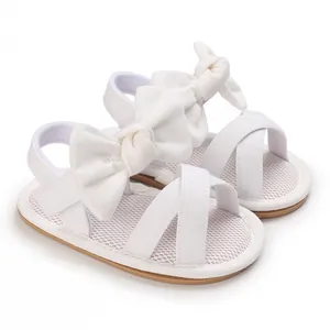 Detailed macro view of white baby girl walking sandals with a cute soft bow design