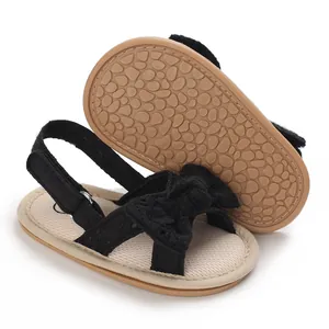 Detail of baby girl sandals showing pebble-patterned anti-slip sole and black bow design