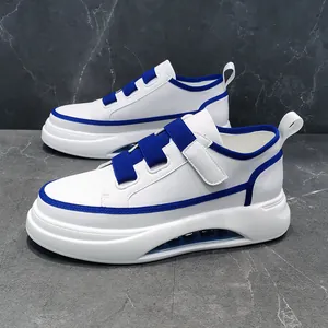 Side detail of white casual men's sneakers with blue straps and platform air cushion sole.