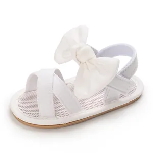 Detail view of white baby girl sandals featuring a large bow and breathable mesh sole.