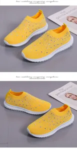 Detalle de zapatillas flyknit amarillas transpirables con elegantes adornos de strass