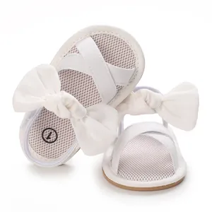 Detailed view of white baby girl sandals featuring a large bow and mesh breathable insole