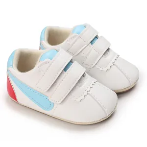 Primer plano de zapatos blancos de suela blanda para bebé con detalles en azul y rojo