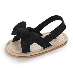 Close-up detail of black baby girl prewalker sandals with a soft sole and cute bow