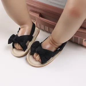 Detailed view of baby girl summer sandals featuring a delicate black lace bow design