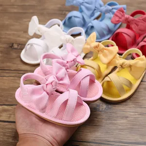 Close-up of pink baby girl sandals with a large bow detail and soft rubber sole