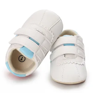 Detalle de zapatos de gateo para bebé en blanco y azul con correas de velcro suaves