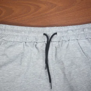 Close-up detail of grey marl sports shorts with elasticated waistband and black drawstring.