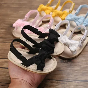 Detailed macro shot of breathable soft-sole baby girl walking sandals with bows.