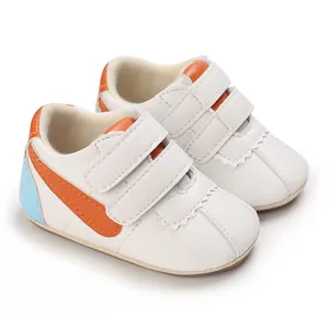 Vista detallada de zapatos blancos para bebé con rayas naranjas y cierre de velcro