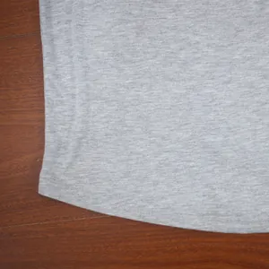 Close-up detail of grey sports t-shirt hem showing high-quality stitching and fabric