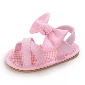 Detailed view of pink baby girl walking sandals with large bow and soft rubber sole