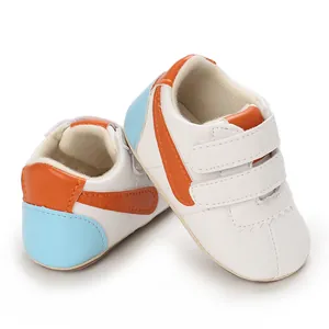 Primer plano de zapatos blancos para bebé con detalles naranja y suela blanda
