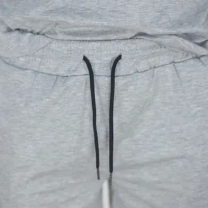Detail view of grey sports shorts showing elastic waistband and black drawstring.