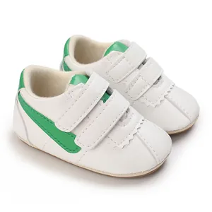 Detalle de zapatos blancos suaves para primeros pasos de bebé con rayas verdes y velcro