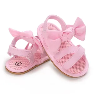 Close-up of pink baby girl sandals with large bow and breathable mesh insole detail