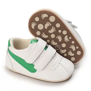 Detalle de zapatos blancos para bebé con rayas verdes y suela antideslizante de huellas
