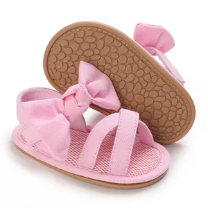 Close-up of pink baby girl sandals with large bow and soft rubber sole