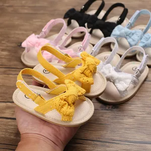 Detail view showing yellow baby girl bow sandals with breathable embroidered texture