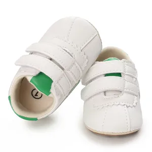 Vista detallada de zapatos blancos para caminar de bebé con detalles verdes y velcro.