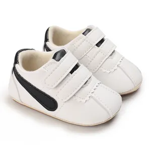 Primer plano de zapatos de bebé blancos para caminar con rayas negras y doble velcro