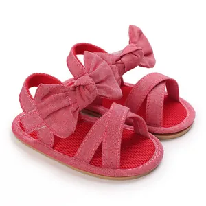 Detailed view of red baby walking sandals featuring large decorative bow accents