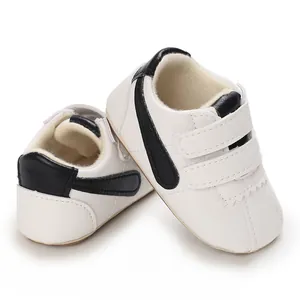 Detalle de zapatos de bebé para primeros pasos en blanco y negro con suela blanda