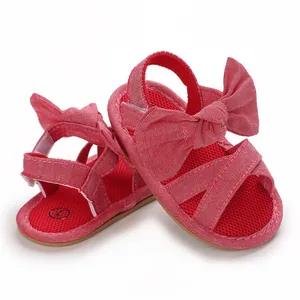 Detailed view of red baby girl sandals featuring a large decorative bow and soft sole