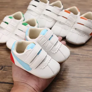 Vista detallada de zapatos blancos para caminar de bebé con suelas blandas y velcro.