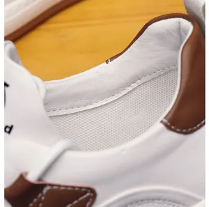 Nahaufnahme des weißen Leder-Sneakers mit atmungsaktivem Mesh-Futter und braunem Rand
