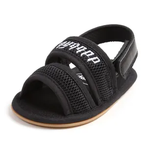 Close-up detail of a black mesh infant sandal featuring a soft sole and embroidered strap