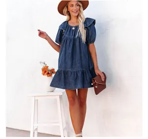 Detalle de vestido corto vaquero informal con mangas de volantes y dobladillo en capas