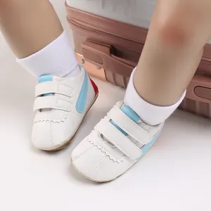 Primer plano de zapatos blancos para bebé con suela blanda y detalles en azul claro