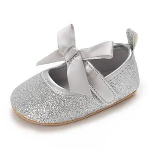 Detail view showing the fine silver glitter texture and satin bow on a baby girl shoe